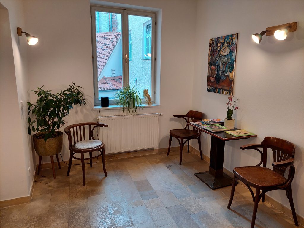 Wartebereich der Gemeinschaftspraxis mit Sitzgelegenheiten am Fenster.