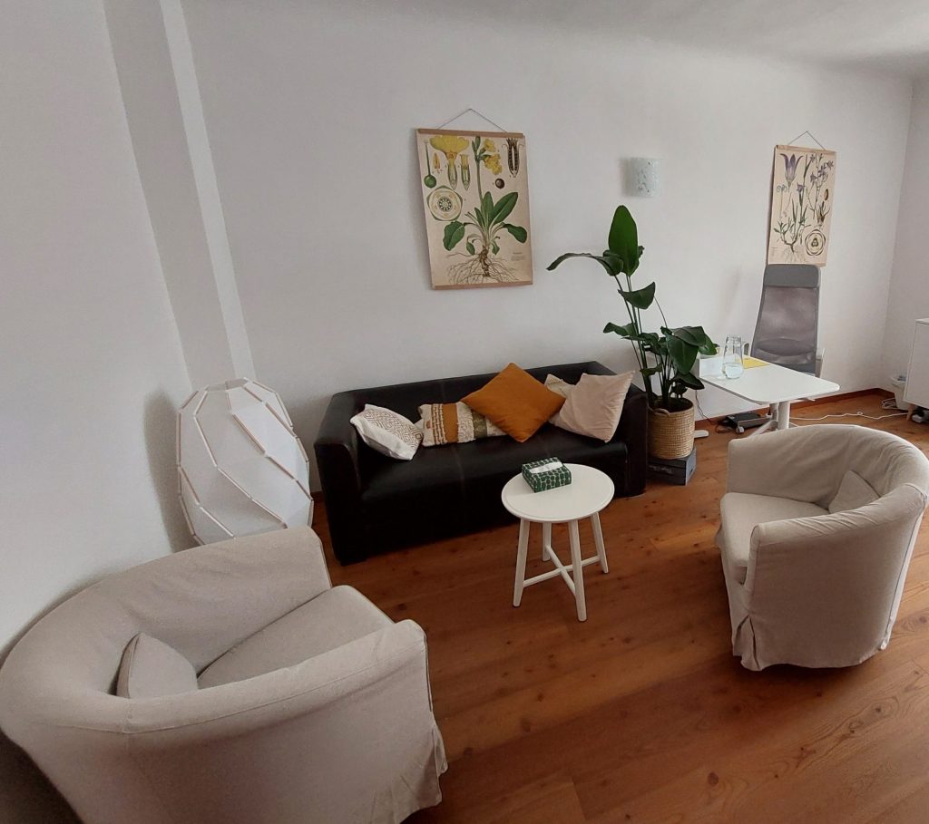 Einblick in den Therapieraum mit Sofa und Sesseln.